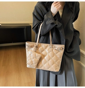 Détail d'un sac cabas beige matelassé avec petit porte-monnaie et boucles métalliques