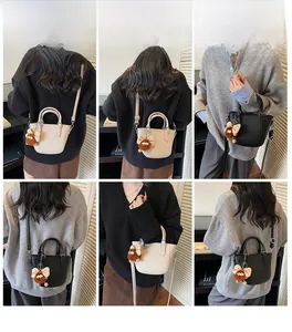 Detailed model views of fashion leather bucket bags in cream and black with charms