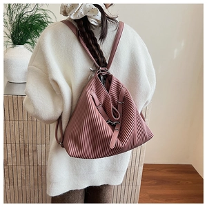 Detailed view of dust pink pleated faux leather backpack with metallic buckle