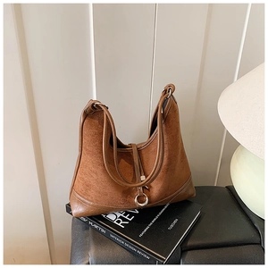 Detail of a brown vintage hobo bag with suede stitching and metallic buckle decoration