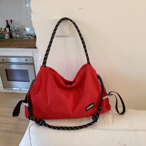 Detail of red nylon tote bag with fashion lettering and rope shoulder strap