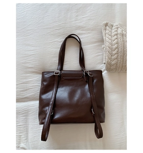 Detail view of large brown vintage plaid tote bag with adjustable straps and metal buckles