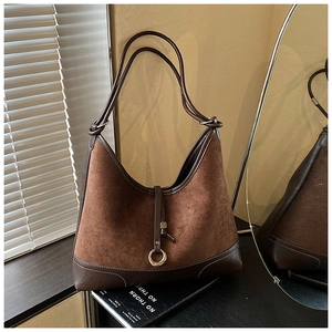 Close-up of retro brown hobo bag with suede leather mix and metal ring detail