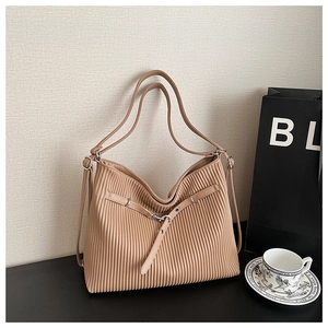 Detailed close-up of brown PU leather tote with vertical pleated texture and silver hardware