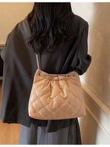 Sac seau matelassé beige avec surpiqûres en losanges et chaîne de luxe gaufrée