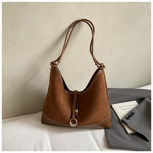 Detail of brown suede tote bag with metal ring buckle and smooth leather stitching