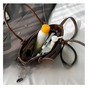 Interior view of brown woven bucket bag showing capacity for phone and cosmetics