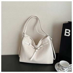 Close-up of white pleated PU leather handbag featuring silver metal buckle and long straps