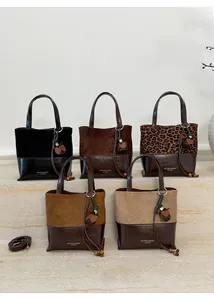 Detailed macro view showing diverse leopard print and suede bucket bags with wood bead tassels