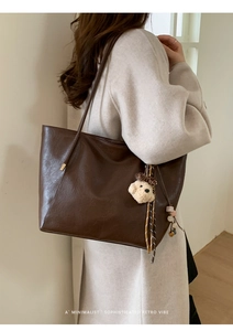 Détail du grand sac cabas rétro marron foncé avec breloque chien en peluche et pompon