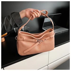 Detail view of peach pink pleated PU leather shoulder bag with decorative metal buckle strap