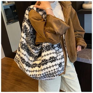 Detail of plush black and white geometric pattern tote bag showing soft fleece texture