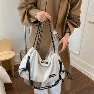 Detail of white canvas tote bag with drawstring closure and fashion woven rope handles