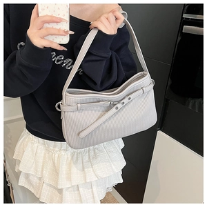 Detail of light grey pleated leather shoulder bag with decorative belt buckle strap