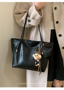 Détail du sac cabas rétro noir avec texture en cuir et charmant porte-clés ours en peluche