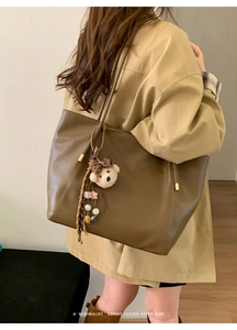 Détail du grand cabas rétro marron avec breloque ours en peluche et chaîne étoilée