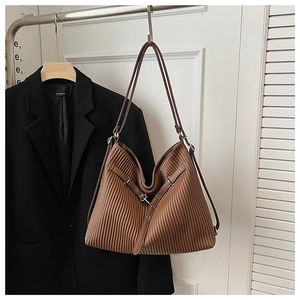Detail view of brown vertical pleated texture on a large capacity leather tote bag