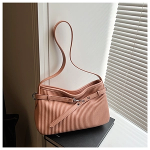 Detail of pink pleated bucket bag with silver eyelets and adjustable leather strap