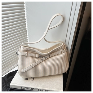 Detail of off-white pleated texture shoulder bag with metallic eyelet decorative strap