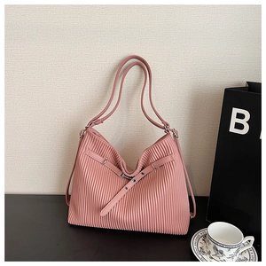 Detail of light pink pleated tote bag with silver buckle and adjustable shoulder strap