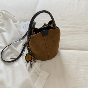 Detail of vintage brown suede bucket bag with yellow floral charm and wooden beads