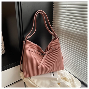 Pink pleated shoulder bag with silver metal buckle detail in a lifestyle setting