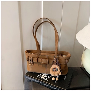 Detail of vintage brown bucket bag with belt buckle on Andrew Martin book