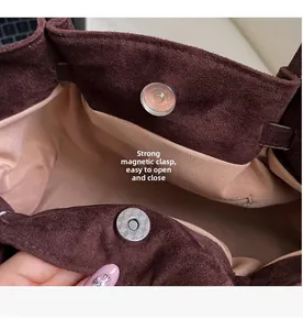 Détail d'un sac en daim marron avec fermeture magnétique et poche intérieure zippée
