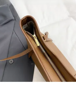 Close-up of golden zipper and textured brown leather on a professional tote bag