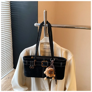 Detail of black matte tote bag with white contrast stitching and brown lion plush charm