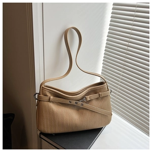 Detail of light brown pleated leather shoulder bag with silver buckle and eyelet belt