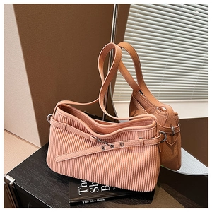 Detail of pleated faux leather shoulder bag with buckle accent and mirror reflection