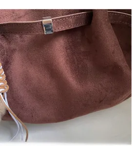 Détail du sac cabas en daim marron foncé avec bandoulière tressée et garniture métal