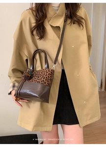 Detail of leopard print bucket bag with leather strap on a beige trench coat