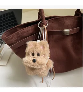 Porte-clés chien en peluche avec plaque TOP DOG sur un sac seau en daim marron chic