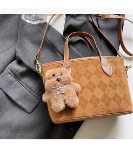 Detail of brown suede bucket bag with F-logo quilting and plush dog charm on a blazer