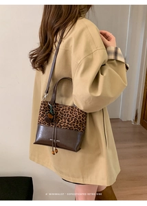Detail of retro leopard print bucket bag with dark brown leather and wood bead charm