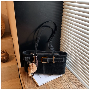 Close-up of black suede tote bag with white contrast stitching and gold buckle hardware