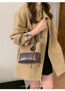 Close-up of retro two-tone suede and leather tote with a rose pendant detail