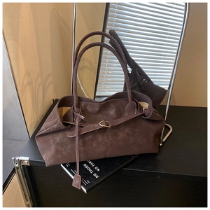 Detail of soft mocha oil wax leather tote bag with elegant draped texture and metal ring