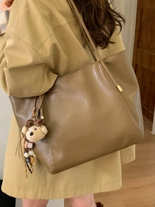 Grand sac cabas rétro kaki avec breloque d'ours porté par un mannequin