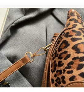 Detail of leopard print handbag with premium gold-tone metal hardware and leather straps