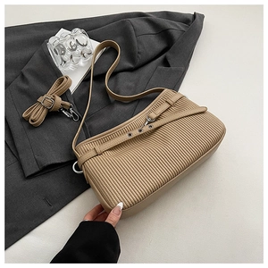 Detail of beige pleated leather bucket bag featuring silver hardware and adjustable strap
