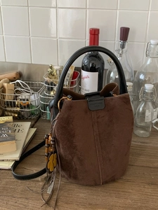 Retro dark brown frosted bucket bag with floral charm and sleek black leather handles