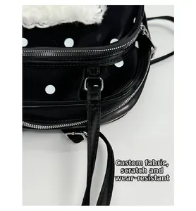 Detail of polka dot bag showing durable scratch-resistant fabric and white plush trim
