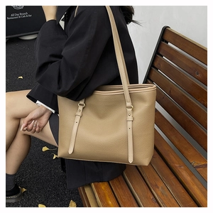 Close-up of khaki pebbled leather tote bag with gold hardware and slim shoulder strap