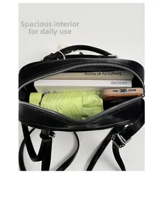 Large capacity black shoulder bag showing interior space with phone, books and umbrella