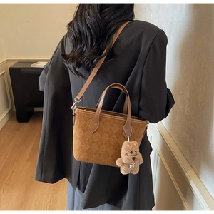 Brown suede tote bag featuring diamond quilt texture and a cute plush bear charm