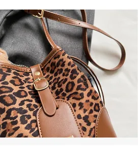 Detailed close-up of leopard print crossbody bucket bag featuring soft fuzzy texture and gold hardware