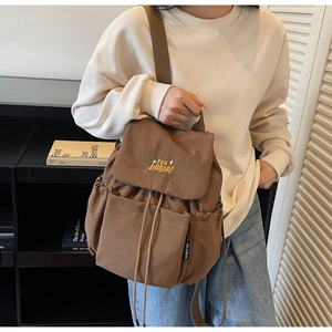 Close-up of brown casual backpack featuring high-quality embroidery and side pocket detail